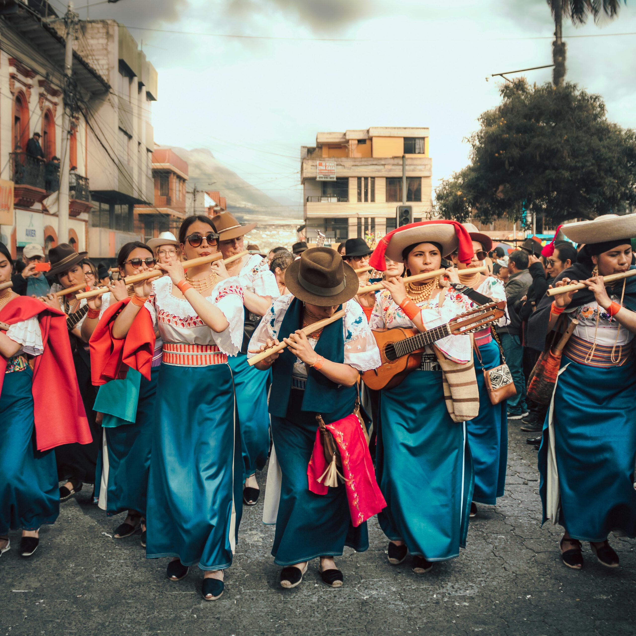 Colorful parade with women musicians in Cotacachi, capturing vibrant Ecuadorian culture.