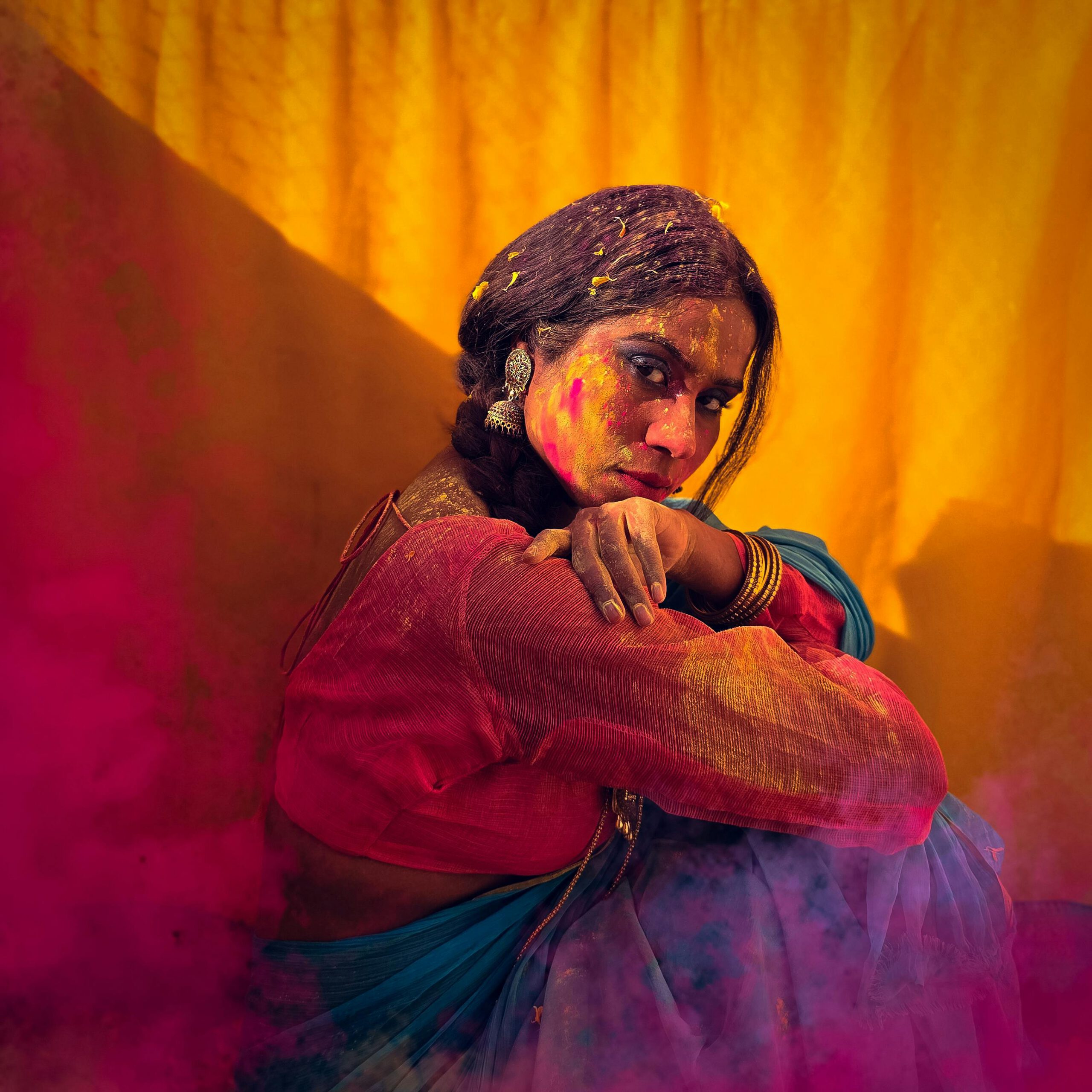 Vibrant portrait of a woman with Holi colors in traditional attire.