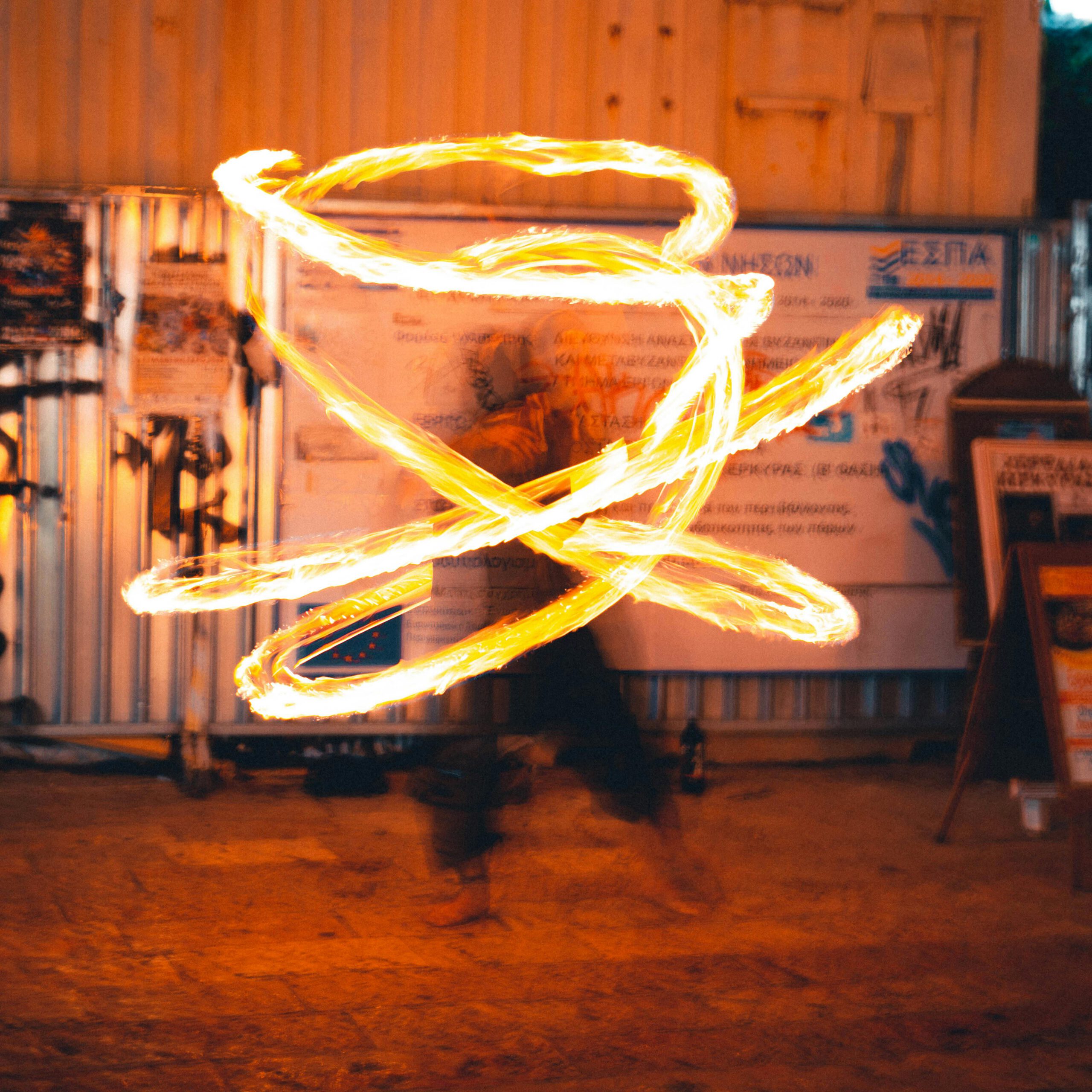 Dynamic fire performance with swirling light trails in an urban setting.